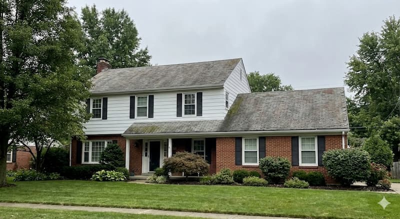 Two-story suburban home with aging roof in need of assessment for repair or replacement